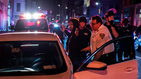 NYPD officers detain a protester who was involved in a looting of a store in the Manhattan borough of New York City