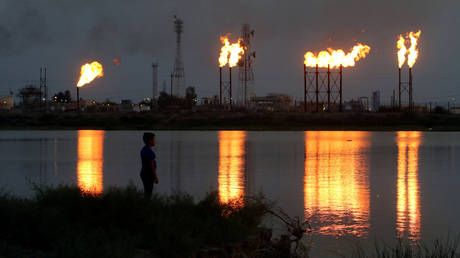 Flames emerge from flare stacks at Nahr Bin Umar oil field, north of Basra, Iraq