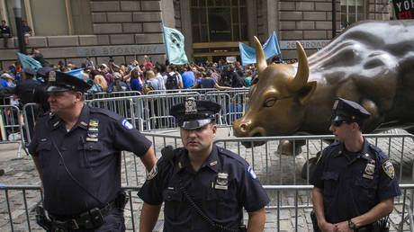FILE PHOTO: New York City police officers stand guard in front of the Charging Bull sculpture © Reuters / Adrees Latif
