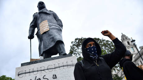 A demonstrator in front of graffiti on a statue of Winston Churchill in Parliament Square during a Black Lives Matter protest in London on Sunday. © REUTERS/Dylan Martinez