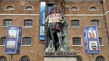 A statue of Robert Milligan covered with a blanket and a placard with a message in reference to the Black Lives Matter campaign in London, Britain, June 9, © Reuters / John Sibley