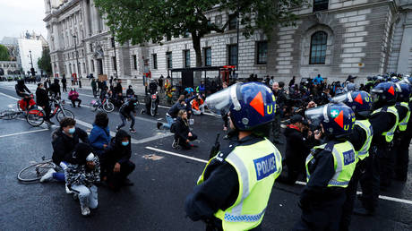 Demonstrators kneel in front of police officers on Whitehall during a Black Lives Matter protest in London, Britain, June 6, 2020