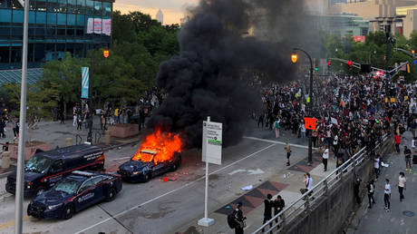 An Atlanta Police car burns as people protest against the death of George Floyd. May 29, 2020 © Reuters / Dustin Chambers