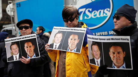 FILE PHOTO: People hold signs calling for China to release Canadian detainees Michael Spavor and Michael Kovrig. © Reuters / Lindsey Wasson