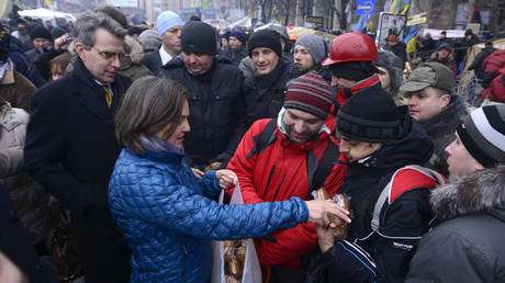 Assistant Secretary of State for European and Eurasian Affairs Victoria Nuland (C) and Ambassador Geoffrey Pyatt (L) distribute pastries at Independence square in Kiev, December 11, 2013.