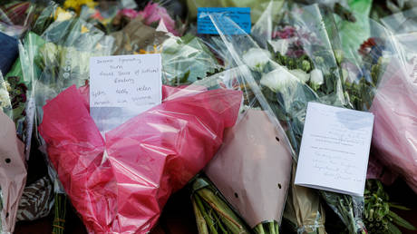 Messages are pictured on the flowers for the victims near the scene of reported multiple stabbings in Reading, Britain, June 22, 2020 © REUTERS/Peter Nicholls