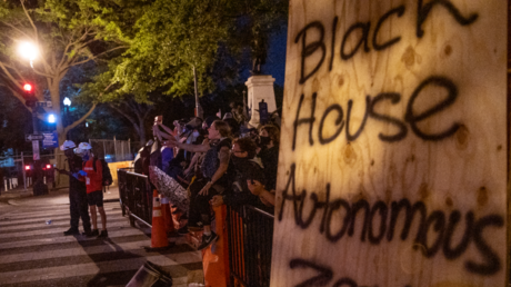 Protesters jeer a line of policemen at the 'Black House Autonomous Zone' near the White House. © ROBERTO SCHMIDT / AFP