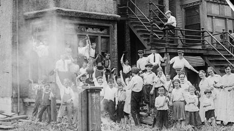 White children cheer outside an African-American residence that they have set on fire. © Getty Images / Bettmann