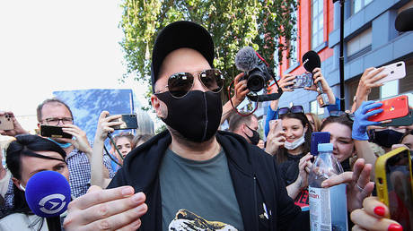 Russian film and theater director Kirill Serebrennikov, wearing a protective mask, walks past journalists and supporters near a court building in Moscow, Russia, June 26, 2020. © REUTERS/Stringer