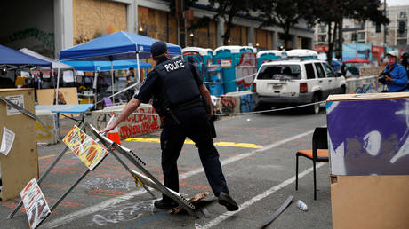 A Seattle Police officer trying to secure a crime scene after a fatal shooting in the CHOP/CHAZ zone, June 29, 2020.