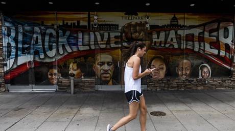 A woman walks past a 'Black Lives Matter' mural near the White House in Washington, DC, June 24, 2020 © AFP / Andrew Caballero-Reynolds