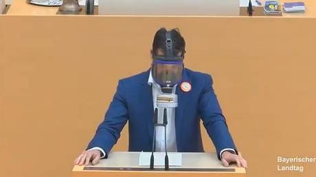 An alternative for Germany MP Stefan Loew speaks while wearing a gas mask © Bavarian State Parliament