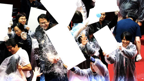 Lawmakers from Taiwan's ruling Democratic Progressive Party (DPP) with lawmakers from the main opposition Kuomintang (KMT) party throw water balloons at each other inside the parliament in Taipei, Taiwan, July 17, 2020. © REUTERS/Ann Wang