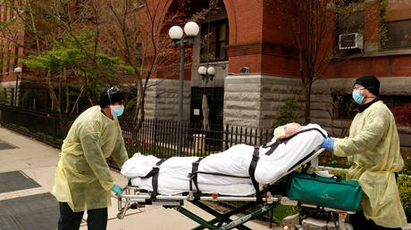 Emergency Medical Technicians wheel man out of Cobble Hill Health Center nursing home in Brooklyn borough of New York