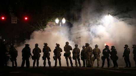 Federal law enforcement officers, deployed under the Trump administration's new executive order to protect federal monuments and buildings, face off with protesters against racial inequality and police violence in Portland, Oregon, U.S., July 21, 2020