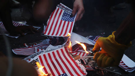 A group of protesters burn American flags and leaflets with the flag, Washington, U.S., July 4, © REUTERS/Leah Millis