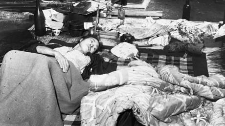 FILE PHOTO: In pallets made up on the floor, a parent reaches out to touch a sleeping child at a makeshift hospital in Hiroshima. © Corbis via Getty Images / CORBIS