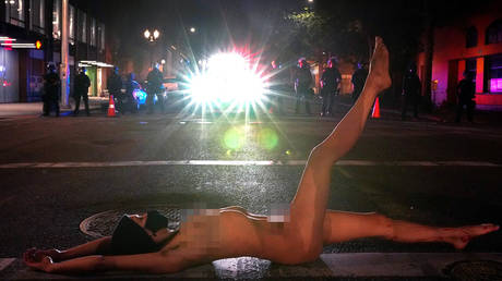 A nude protester faces off against Federal law enforcement officers during a protest against racial inequality in Portland, Oregon, U.S. July 18, 2020.