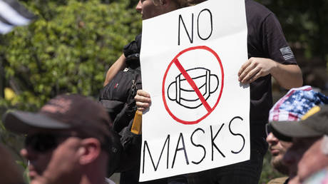 FILE PHOTO: An anti-mask protestor holds up a sign during a right-wing protest "Stand For America Against Terrorists and Tyrants" at State Capitol on July 18, 2020 in Columbus, Ohio.