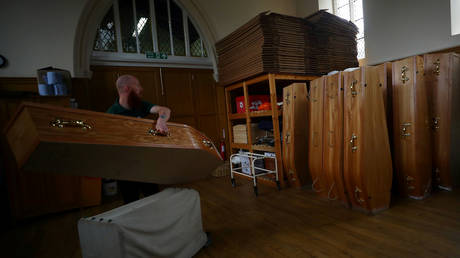 Mortuary worker Aaron Thackray moves a coffin in the mortuary at Poppy's Funerals in Lambeth Cemetery, London © REUTERS/Hannah McKay