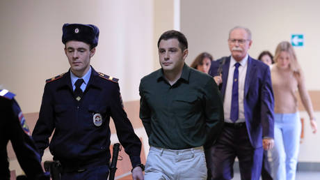 FILE PHOTO: US ex-Marine Trevor Reed is escorted before a court hearing in Moscow, Russia, on March 11, 2020.