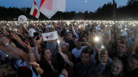 Supporters of presidential candidate Svetlana Tikhanouskaya use the flashlights from their phones during an election campaign rally in Minsk, Belarus July 30, 2020. © REUTERS/Vasily Fedosenko