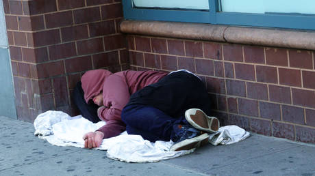 Homeless man sleeping on sidewalk, Gramercy Park, New York City