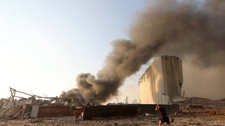 A man runs as smoke rises at the site of an explosion in Beirut, Lebanon, August 4, 2020 © Reuters / Mohamed Azakir