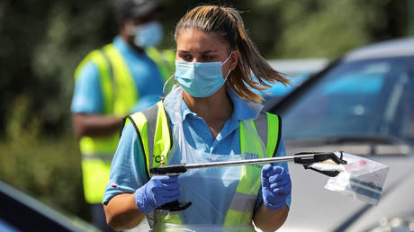 An NHS employee holds a sample at a coronavirus testing center in Stone, UK. © REUTERS/Carl Recine