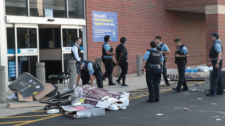 Police officers detain a man who was found inside of a Best Buy store on August 10, 2020 in Chicago, Illinois.