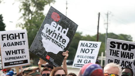 Counter protesters wave signs during a far-right rally on August 15, 2020 near the downtown of Stone Mountain, Georgia