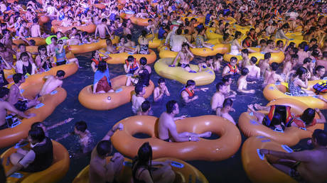 People watching a performance as they cool off in a swimming pool in Wuhan in China's central Hubei province. © STR / AFP