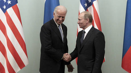 FILE PHOTO: Vladimir Putin (R) shakes hands with Joe Biden during their meeting in Moscow March 10, 2011