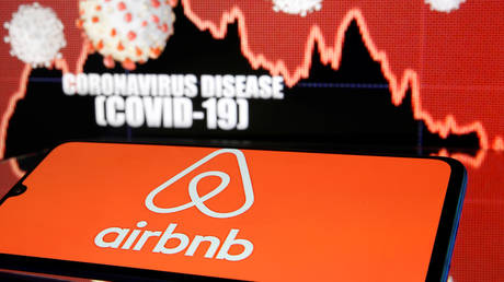 FILE PHOTO. Airbnb logo is seen in front of diplayed coronavirus disease (COVID-19).