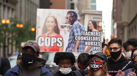 FILE PHOTO: A demonstrator displays a sign at Daley Plaza during a march to demand that police officers be removed from schools in Chicago, Illinois.