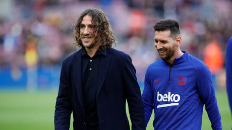 Former Barcelona teammates Carles Puyol and Lionel Messi. © Reuters