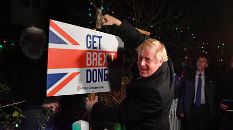 FILE PHOTO: Boris Johnson poses with a sledgehammer, after hammering a "Get Brexit Done" sign into the garden of a supporter. © Pool via REUTERS/Ben Stansall