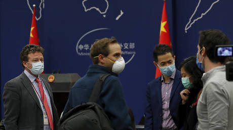 FILE PHOTO: The New York Times Beijing based correspondent Steven Lee Myers, left, chats with other foreign journalists after attending a daily briefing by Chinese Foreign Ministry spokesman Geng Shuang at the Ministry of Foreign Affairs office in Beijing, Wednesday, March 18, 2020.
