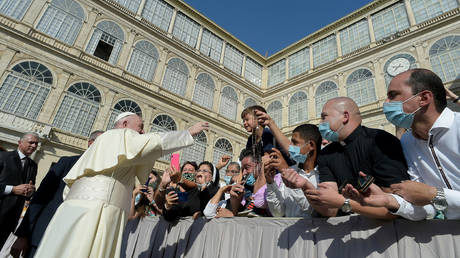 Pope Francis greets a child at the San Damaso courtyard during the weekly general audience at the Vatican September 9, 2020. © Reuters / Vatican Media