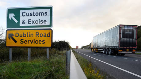 FILE PHOTO: A semi-truck passes a sign for Customs and Excise on a road near the border with Ireland near Kileen, Northern Ireland.