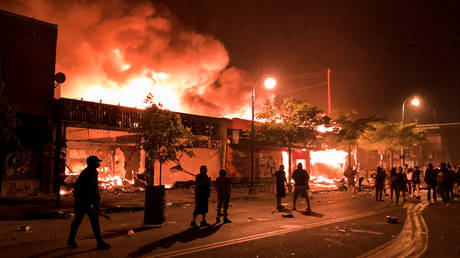 Flames rise from a liquor store and shops near the Third Police Precinct on May 28, 2020 in Minneapolis, Minnesota, during a protest over the death of George Floyd.