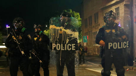 Police officers stand guard as people take part in a protest in Portland, Oregon, September 18, © Reuters / Shannon Stapleton