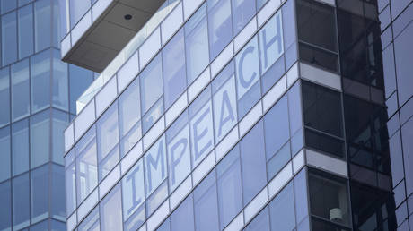 FILE PHOTO: A window in an apartment with the saying "IMPEACH" overlooking Madison Square Park where the 45th President Donald J. Trump was giving his opening ceremony of the 100th annual Veterans Day Parade in the Manhattan borough of New York on November 11, 2019, USA