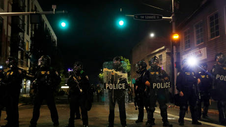 Police officers stand guard as people take part in a protest against racial injustice, in Portland, Oregon, U.S., September 18, 2020