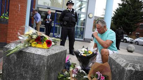 A man reacts as flowers are laid down outside the custody centre where a British police officer has been shot dead in Croydon, south London, Britain, September 25, 2020 © REUTERS/Tom Nicholson