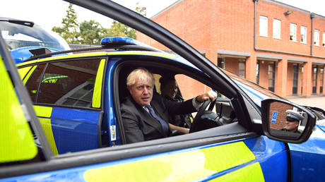 Boris Johnson sits in a police vehicle during a visit to Northamptonshire Police Headquarters, September 24, 2020 © Reuters / Stefan Rousseau