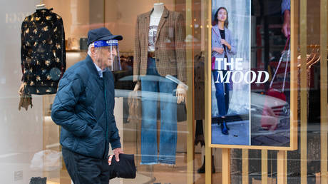 A shopper wearing a protective visor on Regent Street, London, after a range of new restrictions to combat the rise in coronavirus cases came into place in England.