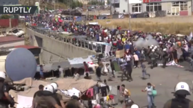 WATCH: Greek police fire tear gas at migrants protesting after blaze at Europe’s largest refugee center