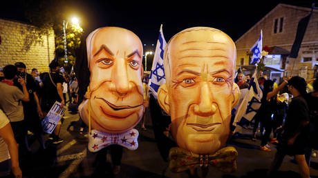 Demonstrators wear masks depicting Israeli PM Benjamin Netanyahu and Israel's Alternate PM and Defense Minister Benny Gantz during a protest in Jerusalem, August 8, 2020. © Reuters / Ronen Zvulun