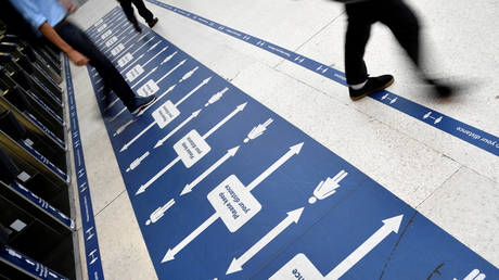 People pass social distancing markers at Waterloo station in London, Britain, September 7, 2020.